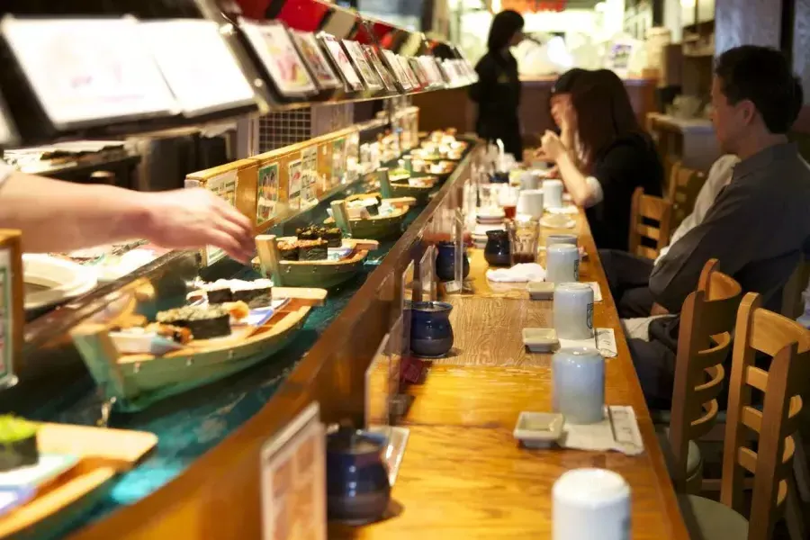 Image de sushis naviguant sur des mini-bateaux